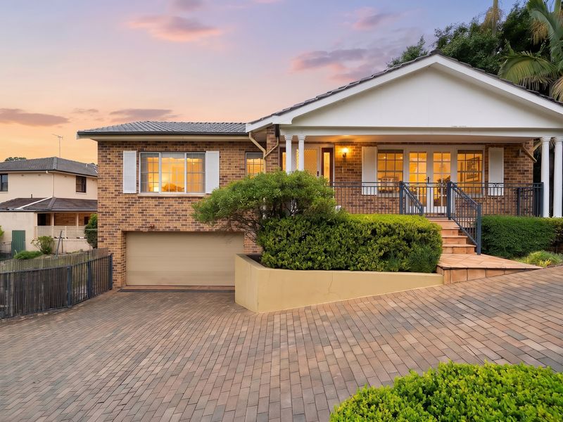 Warm dusk exterior view highlighting the home's architecture and driveway.