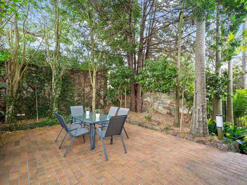 Private outdoor patio surrounded by trees and lush greenery.