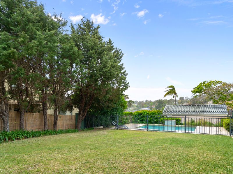 Expansive view of the open lawn and green backyard trees.