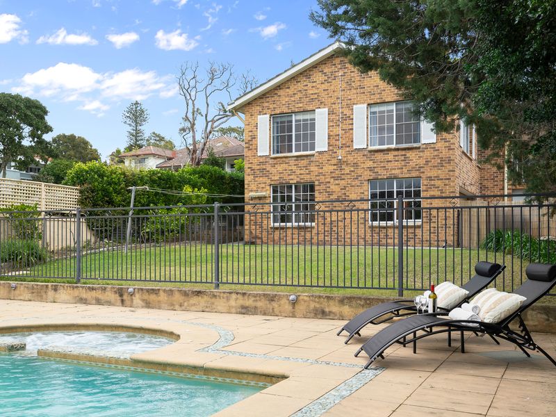 Backyard pool area overlooking the lawn and perimeter fencing.