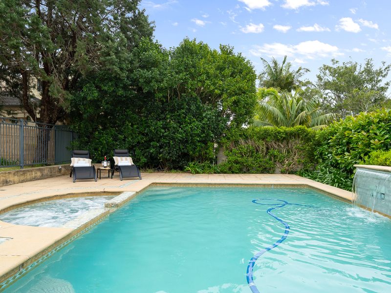 Scenic angle of the swimming pool with lush tropical trees in the background.