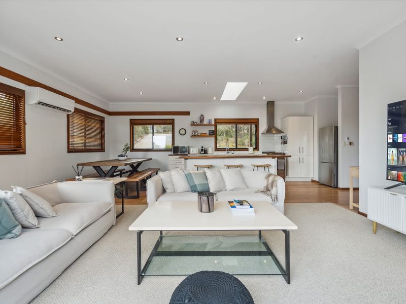 Bright open-plan room combining the main lounge, dining table, and kitchen.