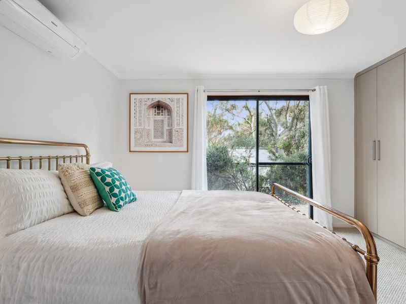 Bright bedroom with large windows bringing in plenty of natural light.
