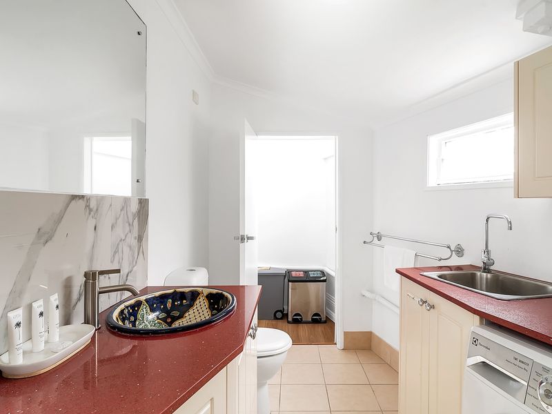 Classic-style bathroom offering both shower space and laundry access.
