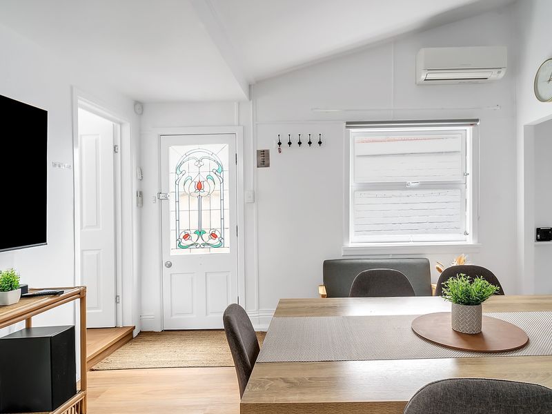 Central living space with sofa, smart TV, and dining table.