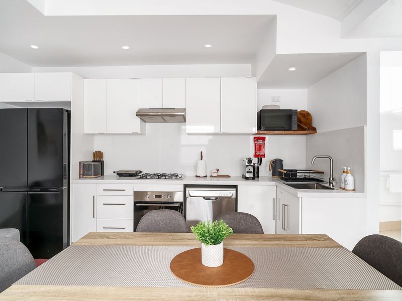 Functional kitchen with stovetop, oven, and modern appliances.