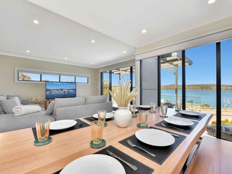 Stylish open-plan living and dining area featuring stunning waterfront views.
