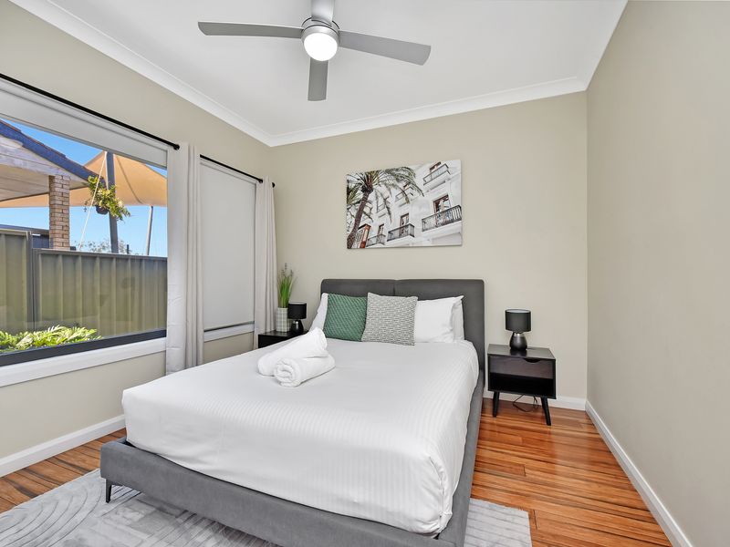 Modern and bright bedroom featuring a comfortable double bed, ceiling fan, and stylish décor.
