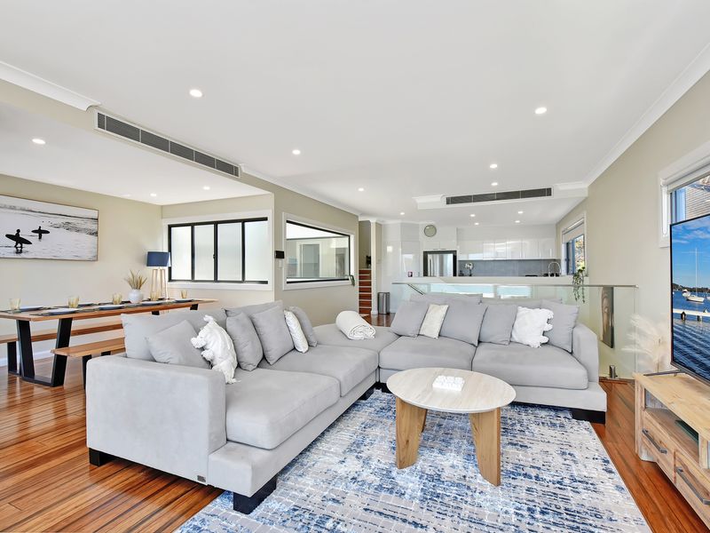 Spacious open-plan living area featuring a large comfortable sectional sofa, modern décor, and a flat-screen TV.