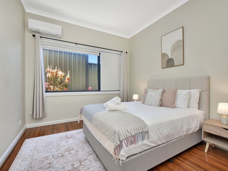 The room includes modern furnishings and a large window offering plenty of natural light.