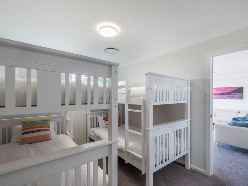 Rest easy in this bright, cheerful room featuring sturdy bunk beds and a seamless connection to the cozy living area.