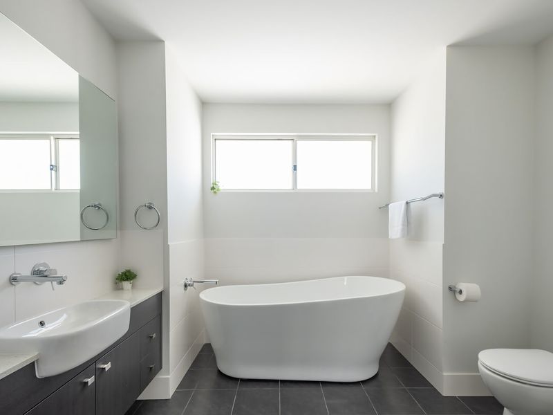 Relax in this bright and modern bathroom featuring a luxurious freestanding tub.