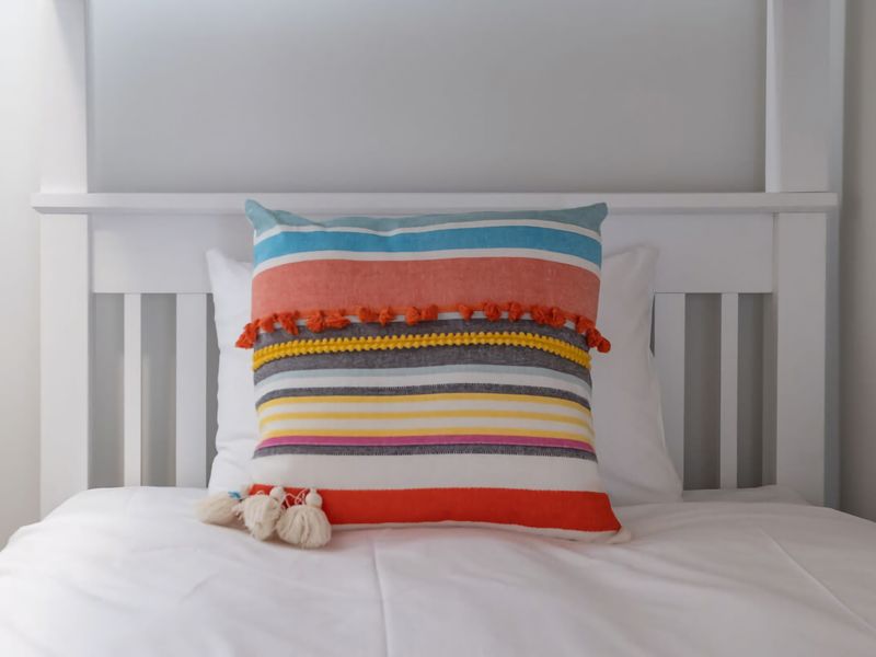 Add a pop of color to your stay with this cheerful, boho-inspired accent on crisp, comfortable bedding."