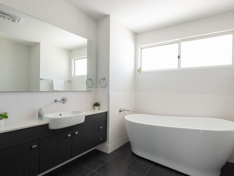 Unwind in this bright, modern sanctuary featuring a deep soaking tub and sleek, contemporary finishes.