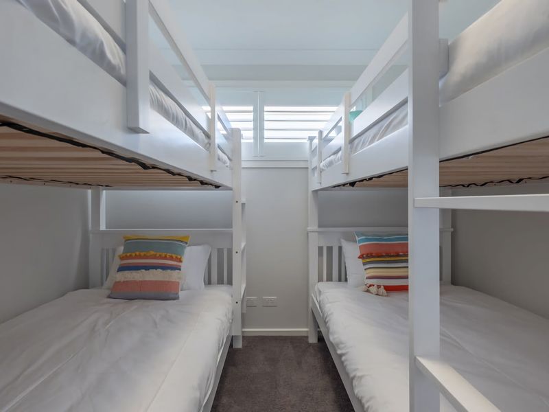 Enjoy a bright and cozy retreat with these modern, beach-inspired bunk beds perfect for the whole family.