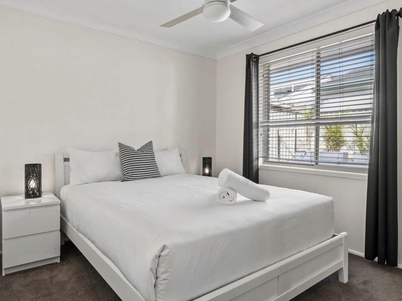 Queen bedroom with ceiling fan and cozy coastal styling.