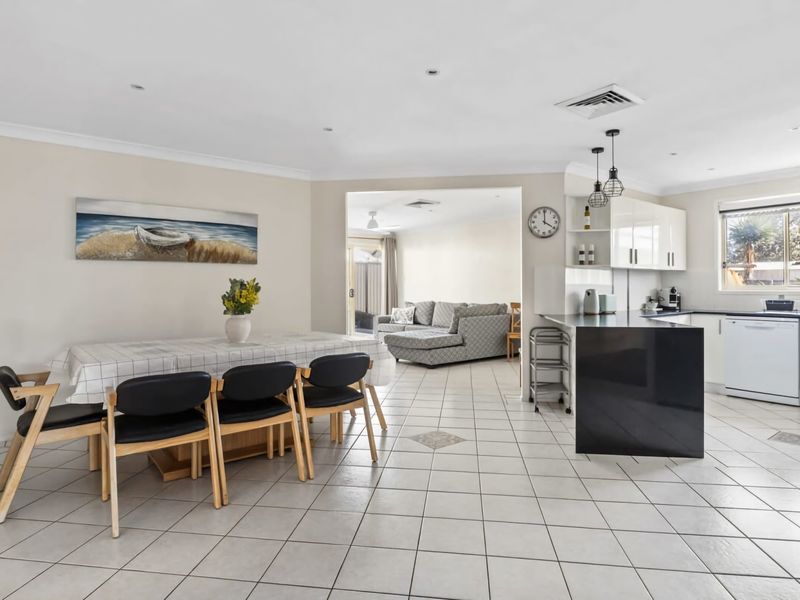Open-plan living area with lounge, dining table, and kitchen in one connected space.