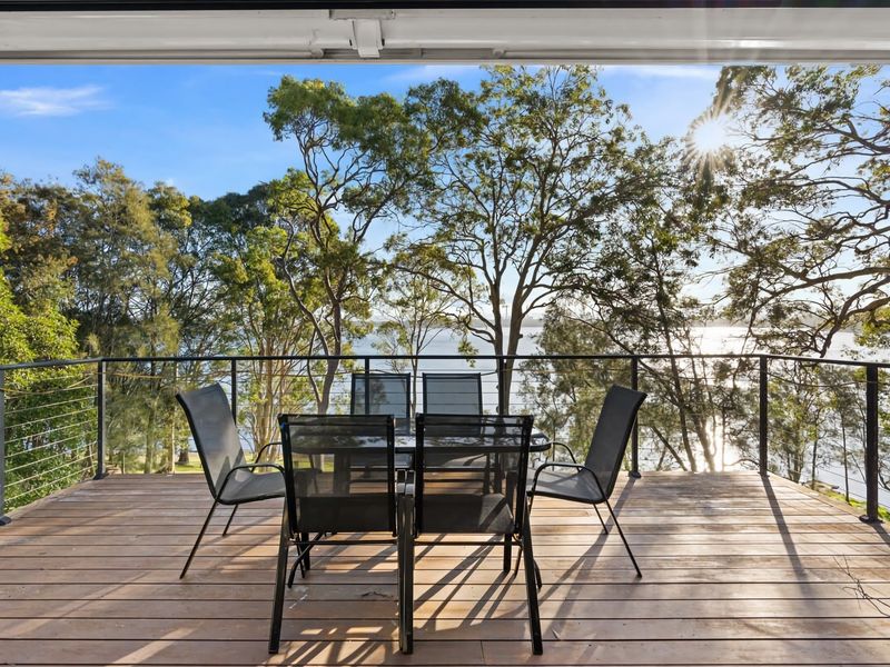 Spacious deck with seating and leafy surrounds.