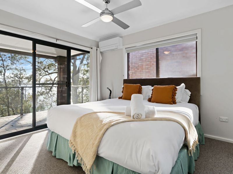 Inviting bedroom with large windows and peaceful outlook.