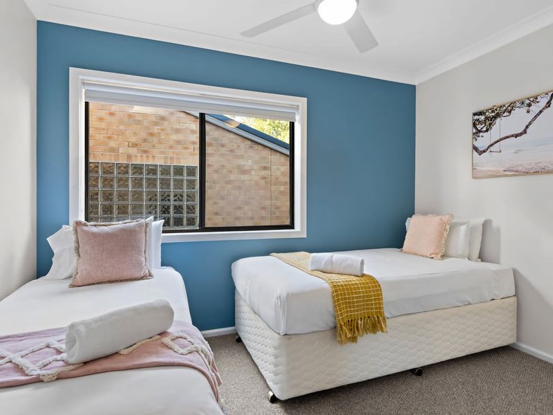 Flexible bedroom setup with twin beds and calming blue walls.