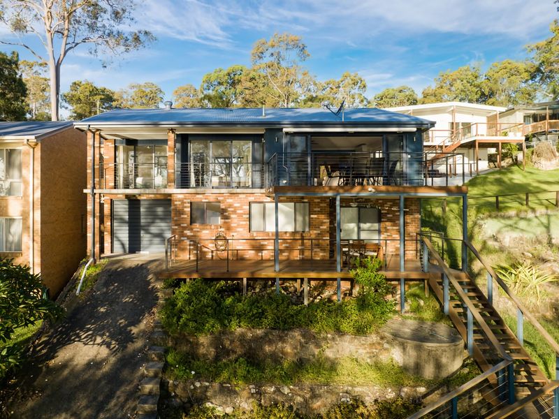 Rear view of the home nestled among lush greenery.