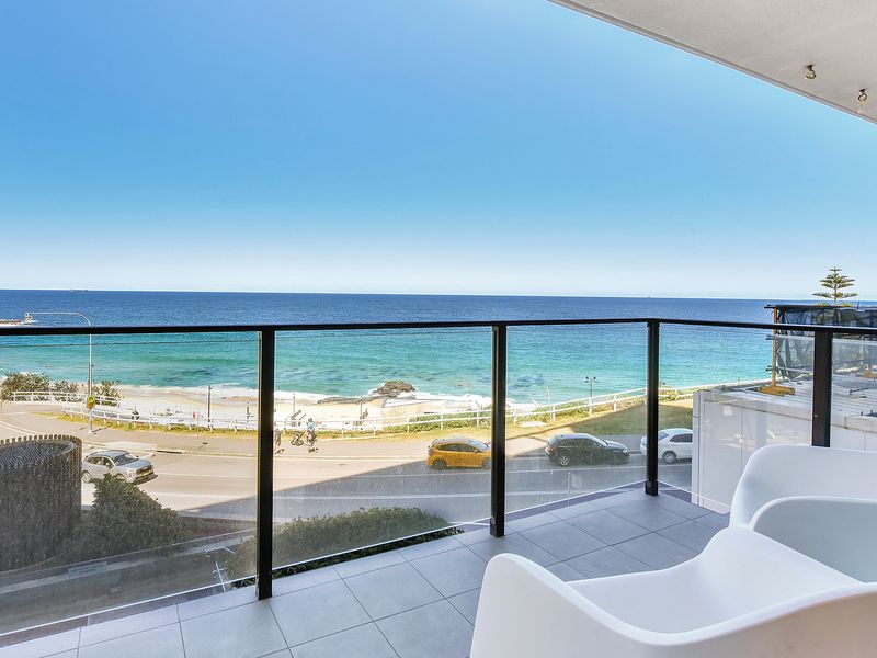 Spacious balcony with modern seating and stunning ocean front views.