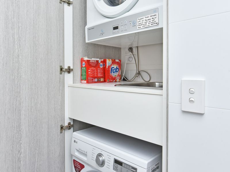 Features a premium stacked LG washer/dryer set, cleverly concealed behind a stylish door. Includes a handy integrated sink and utility shelf for ultimate space-saving functionality.