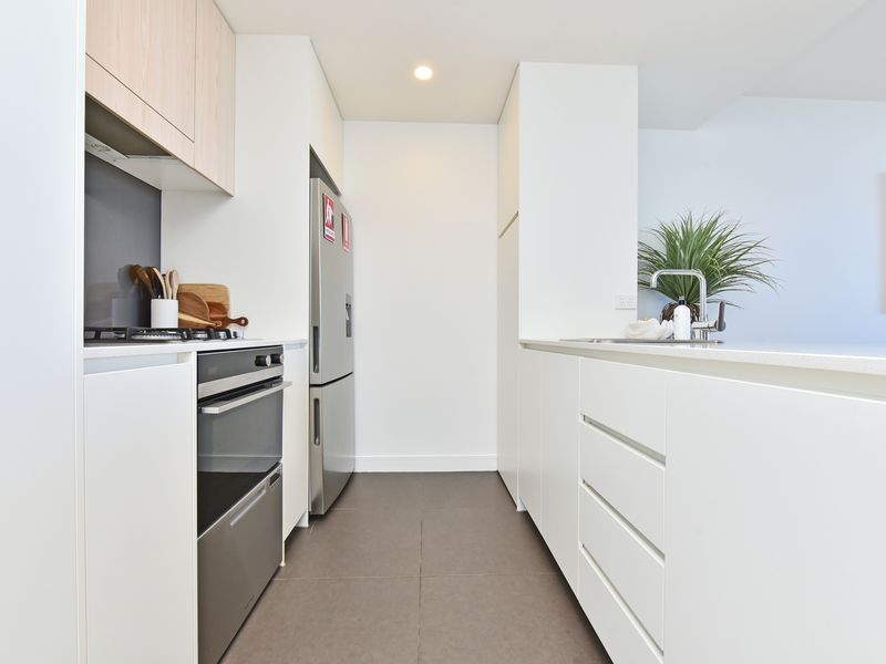 Sleek modern kitchen with stainless steel appliances, white cabinetry and ample counter space.
