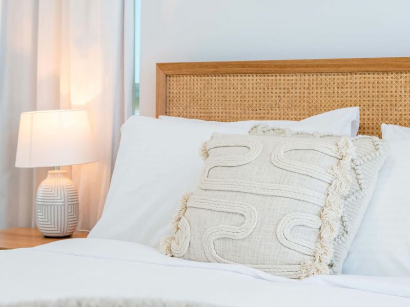 Woven rattan headboard and crisp white linens. The perfect spot to recharge.