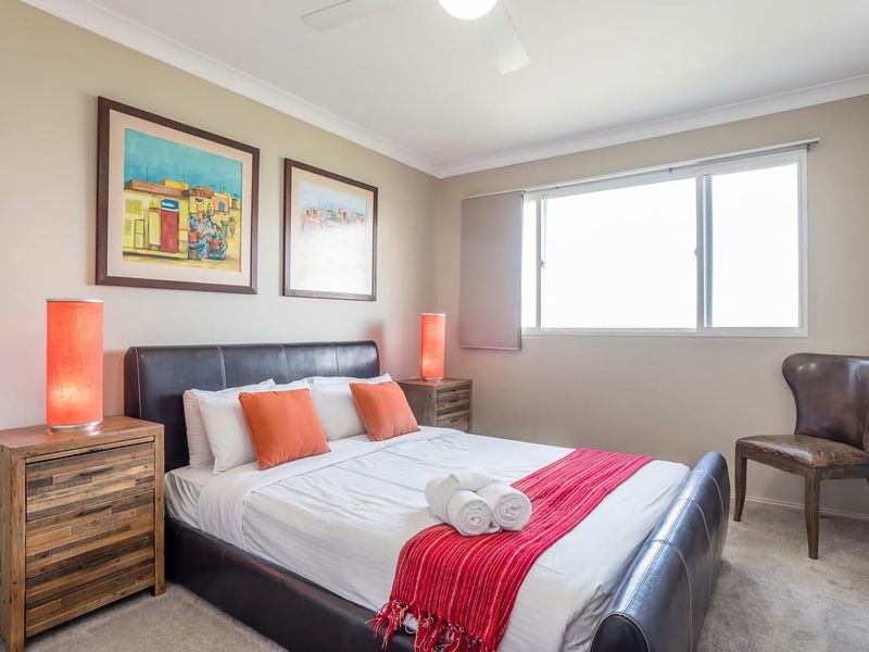 The master bedroom comes furnished with a Queen sized bed, window and extra sitting chair