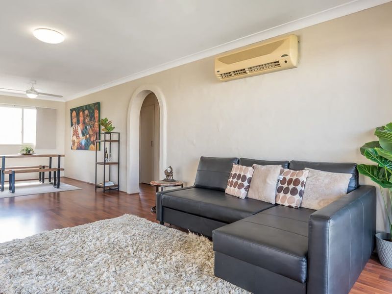 The living room offers a comfy couch situated in a spacious open-plan with access to a private balcony, perfect for unwinding during the day or at night