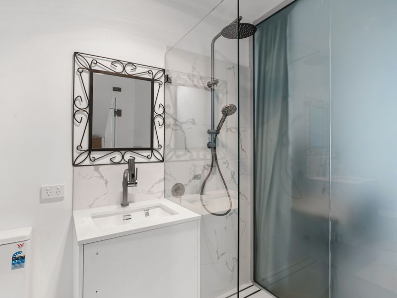A sleek and modern private bathroom in your suite studio, designed for comfort and convenience with everything you need for a relaxing stay.