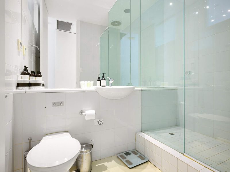 Another view of the bathroom, featuring a glass-enclosed shower area