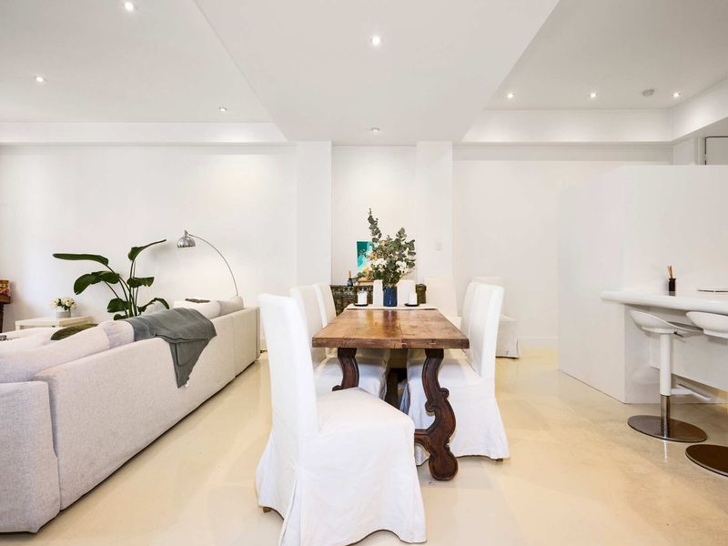 Elegant dining area with a rustic wooden table, adjacent to the living space