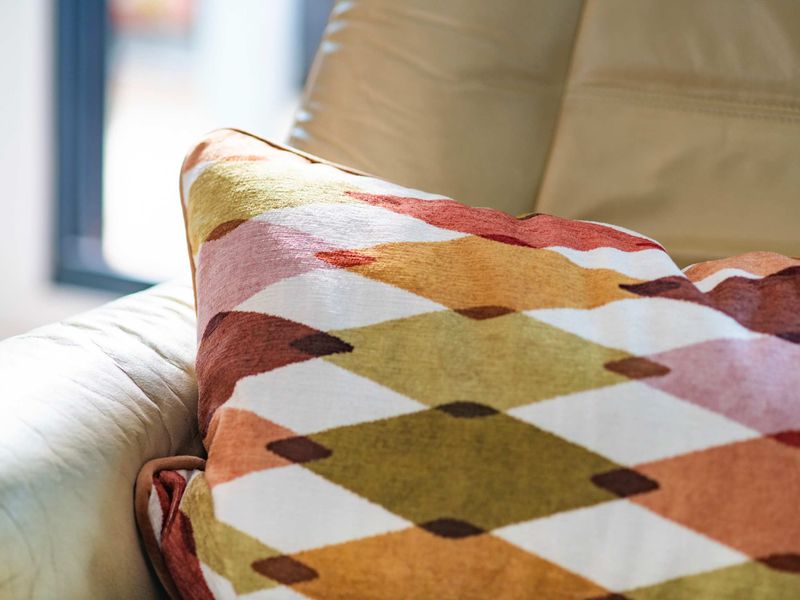 Comfortable lounge chair with a colourful cushion, ideal for relaxation