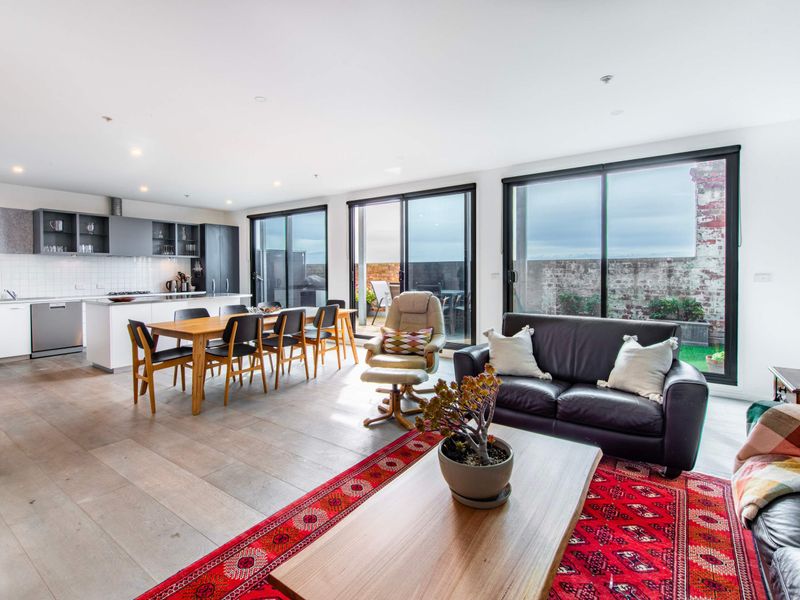 Bright and spacious open-plan living area with modern kitchen, dining space, and cozy lounge, perfect for relaxing and entertaining.