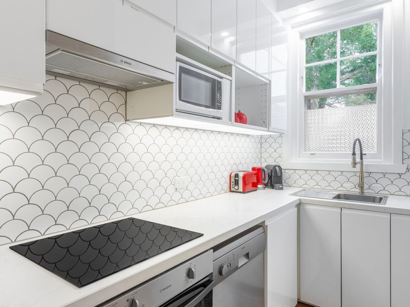 Modern kitchen with sleek cabinetry, tiled splashback and quality appliances