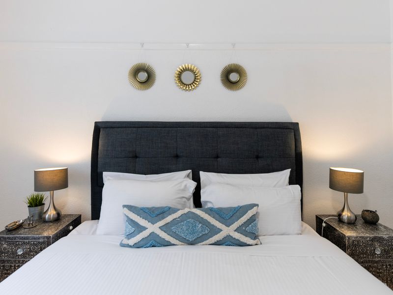 King bedroom with feature headboard, bedside lighting and a balanced, modern look