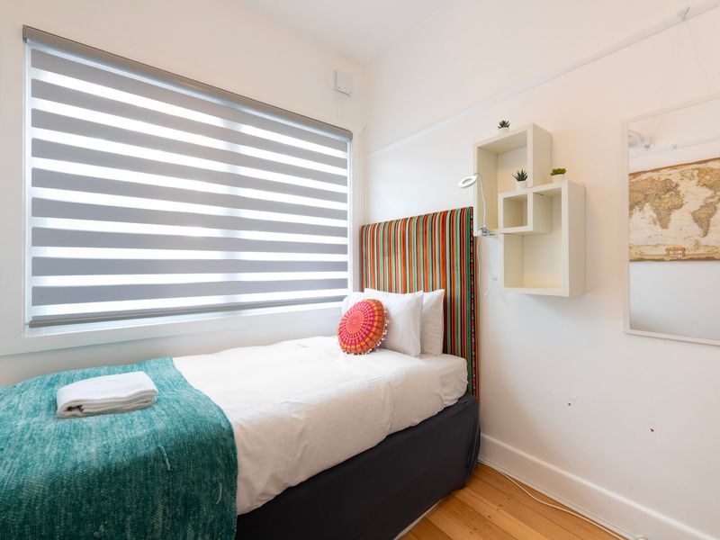 Light filled single bedroom with soft textiles and a calm, restful setting