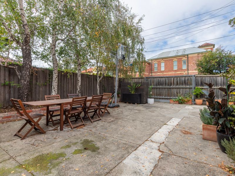 Shared spacious outdoor courtyard area with dining setting and leafy surrounds