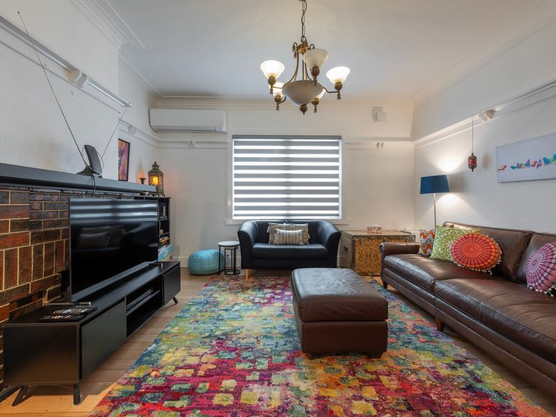 Spacious living room with leather sofas, statement rug and plenty of natural light