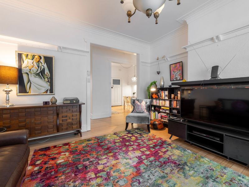 Character filled living room with rich textures, leather seating and a vibrant feature rug