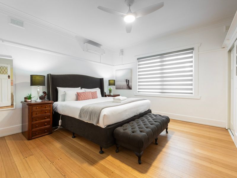 Generous King bedroom with plush bedding, timber floors and a calm, airy feel