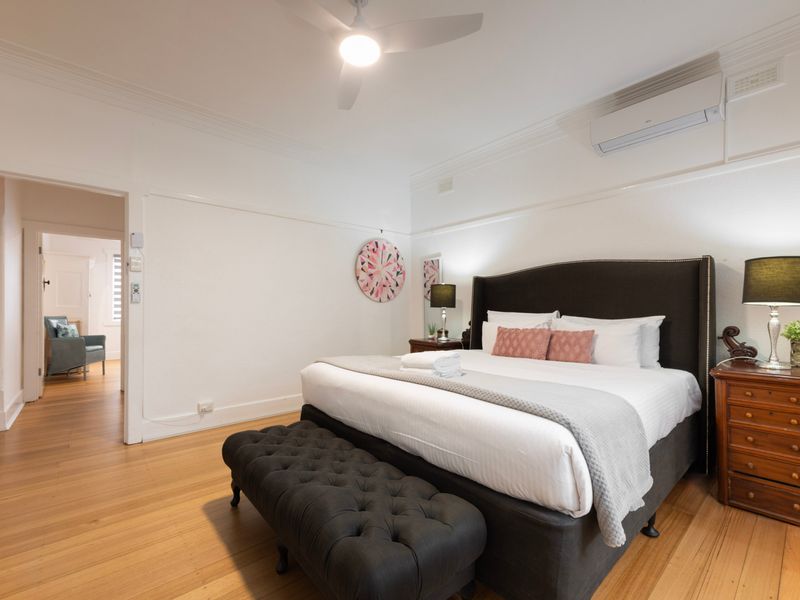 King bedroom with soft styling, timber floors and ample space to unwind