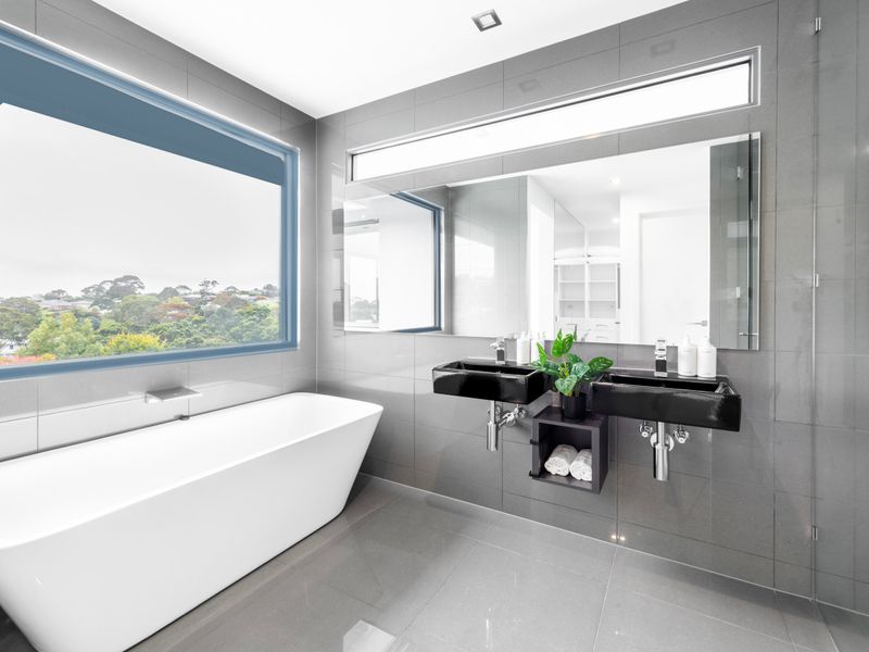 Sleek modern bath with large windows and nature views