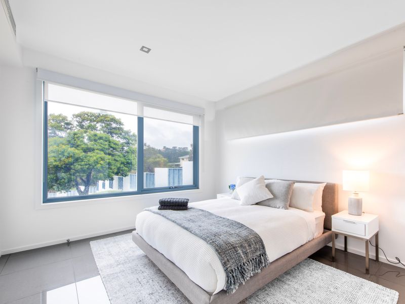Guest bedroom with calming tones and leafy outlook