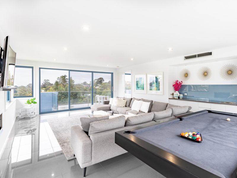 Spacious entertainment room with pool table and large windows.