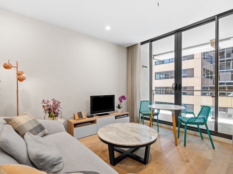 Living room goals: Perfectly appointed with a cozy couch, TV, and a balcony for some fresh air.