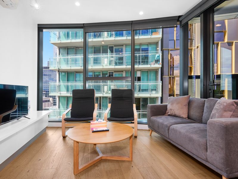 Bright living room with floor to ceiling windows and city outlook