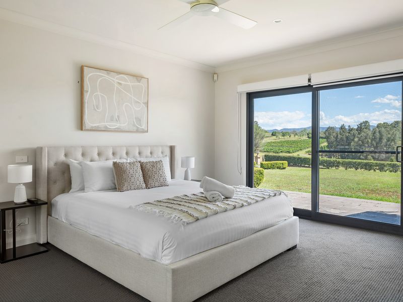 Wake up to stunning vineyard views in this master bedroom